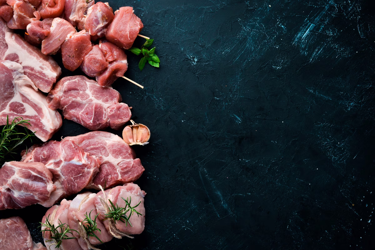 raw-meat-barbecue-meat-with-spices-herbs-black-stone-background-top-view-free-copy-space-min